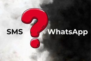 SMS vs WhatsApp: a visual comparison showing two messaging channels divided by a red question mark against a smoke background.